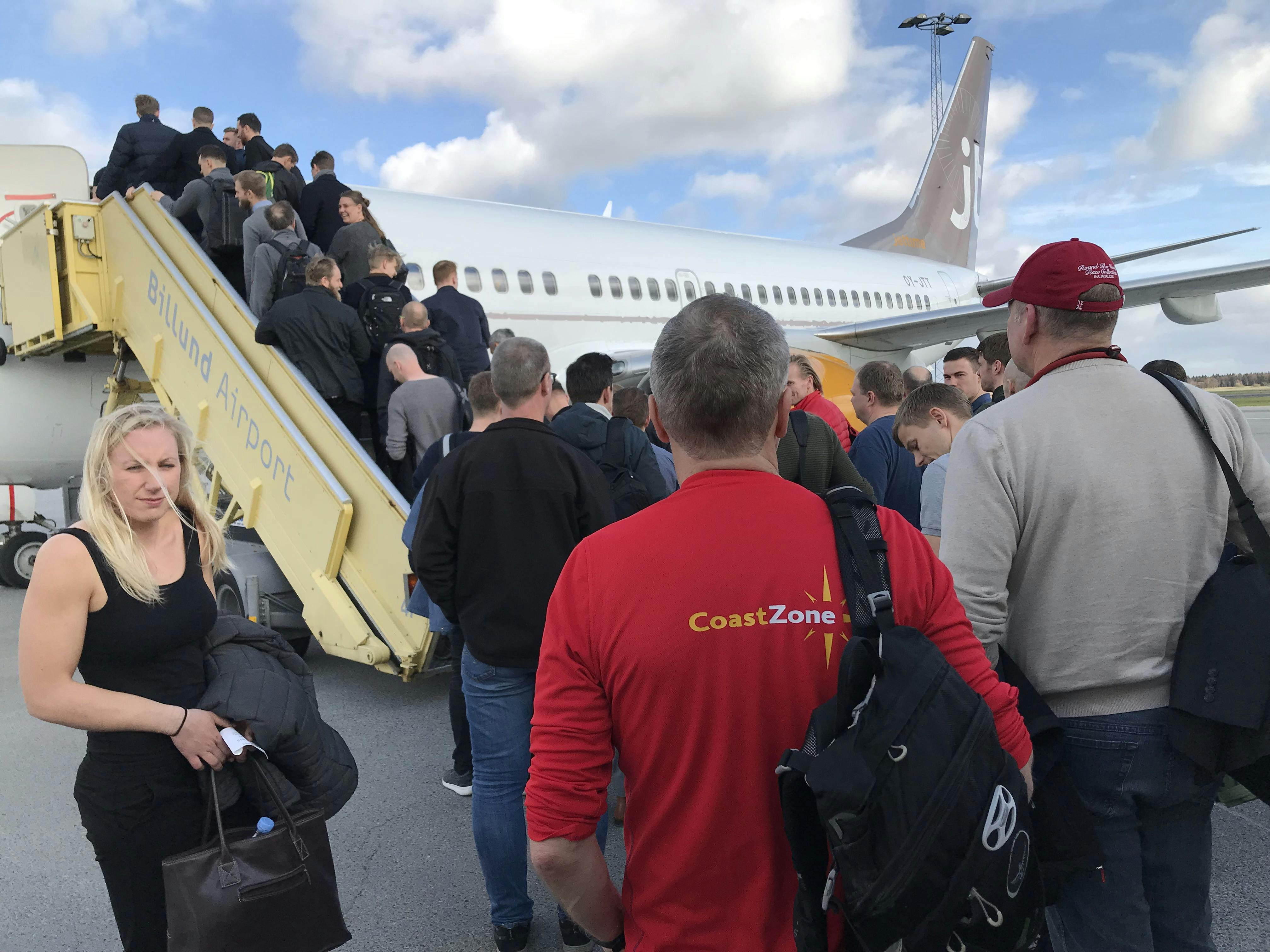 Mennesker der går ombord på et fly for at komme på firmatur til udlandet