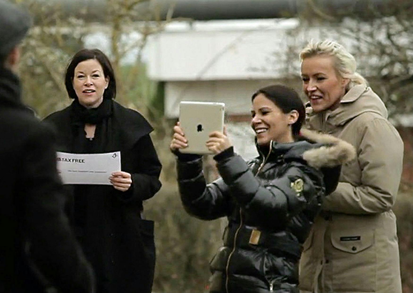 Tre kvinder optager en video på en iPad under teambuildingaktiviteten Make a Movie