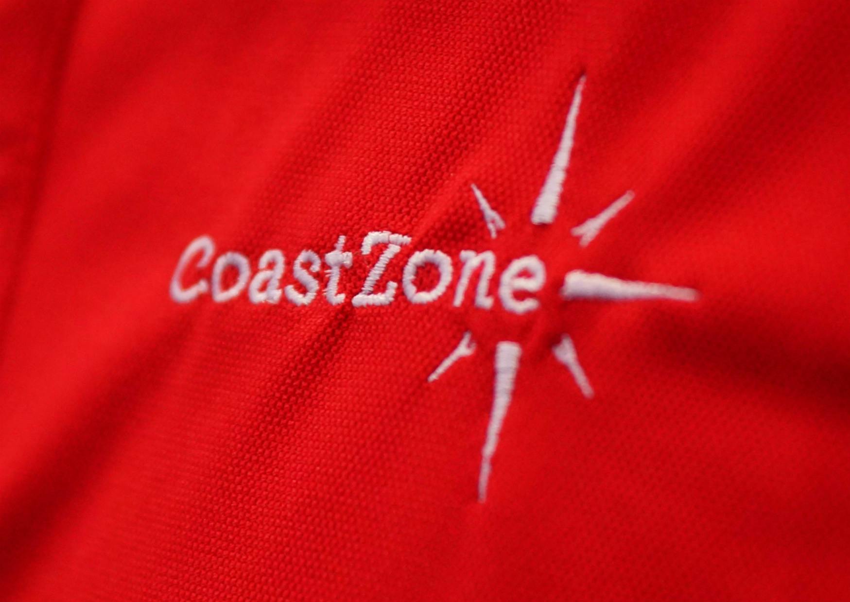 Nærbillede af bluse med CoastZones logo