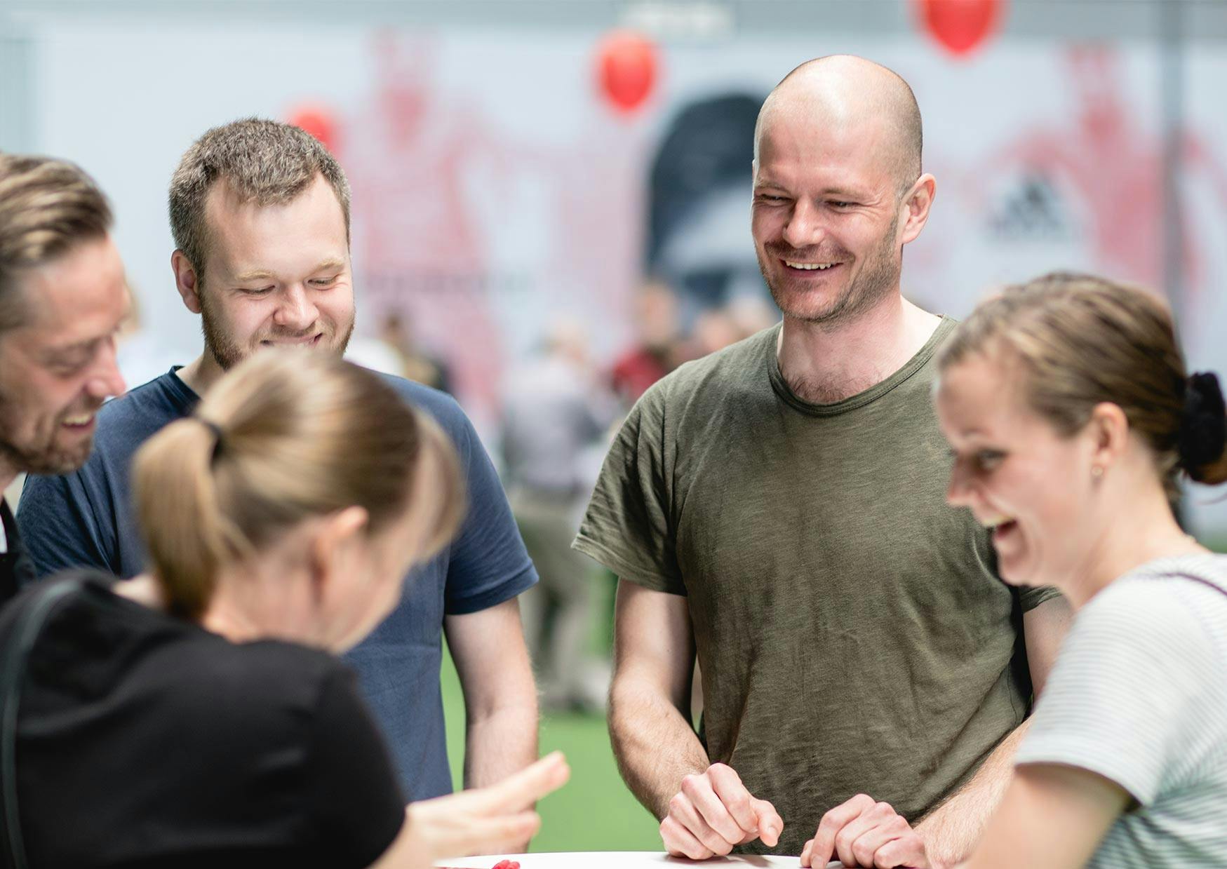 Fem medarbejdere samlet rundt om et bord til et firmaarrangement i København