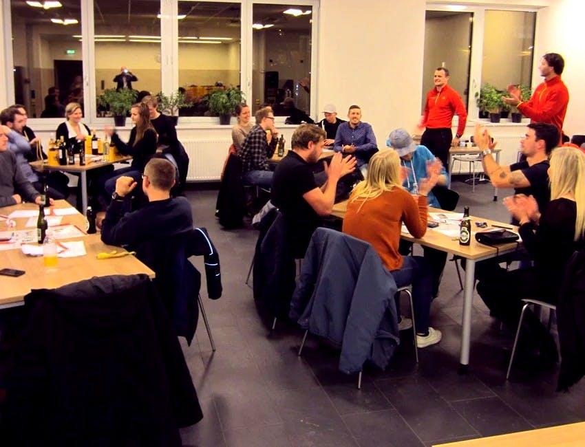 Personaledag med teambuilding hvor medarbejderne er samlet i et mødelokale og fordelt ved fire borde 